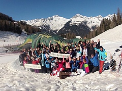 Große Gruppe von SKifahrern vor Bergkullisse