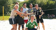 Gruppe von Jugendlichen in Sportbekleidung halten glücklich Trophäe in der Hand