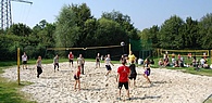 Gruppe von Jugendlichen spielt Beach Volleyball